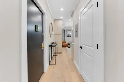 a hallway with white walls and a white door at Modern 3Bd Rose Hills Manhattan Terrace Space in New York