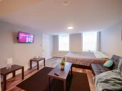 a living room with a bed and a couch at Bright and Airy Studio Apt Minutes to NYC in Jersey City