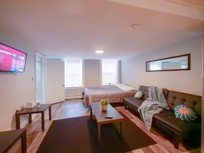 a living room with a couch and a bed at Bright and Airy Studio Apt Minutes to NYC in Jersey City