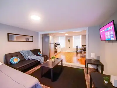 a living room with a couch and a flat screen tv at Bright and Airy Studio Apt Minutes to NYC in Jersey City
