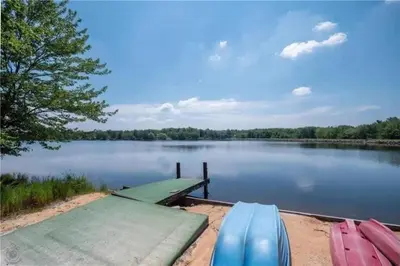 three boats are docked at a dock on a lake at 5-Bedroom Lakefront, private beach wifi AC boat & in Tobyhanna