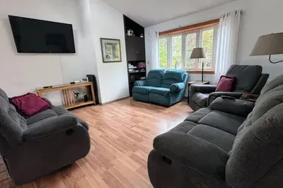 a living room with two couches and a tv at 5-Bedroom Lakefront, private beach wifi AC boat & in Tobyhanna