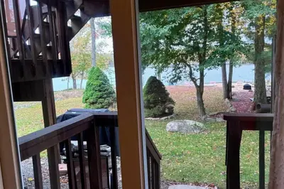 a view of a yard from a balcony at 5-Bedroom Lakefront, private beach wifi AC boat & in Tobyhanna