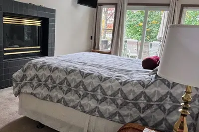 a bedroom with a bed and a fireplace at 5-Bedroom Lakefront, private beach wifi AC boat & in Tobyhanna
