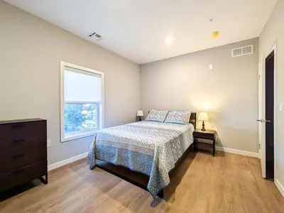 a bedroom with a bed and a dresser and a window at 313 brand new 3 bedroom 2 bath in Dunellen