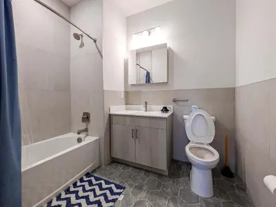 a bathroom with a toilet and a sink and a tub at 313 brand new 3 bedroom 2 bath in Dunellen