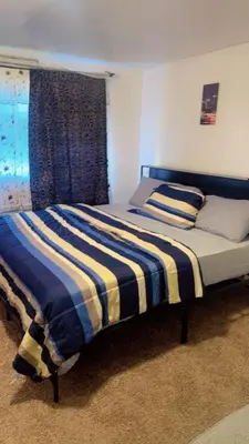 a bedroom with a bed with a striped blanket at UD guest house in East Orange