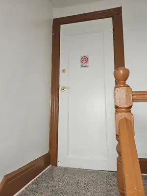 a white door with a no smoking sign on it at UD guest house in East Orange