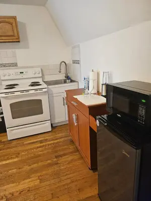 a kitchen with white appliances and wooden floors at UD guest house in East Orange