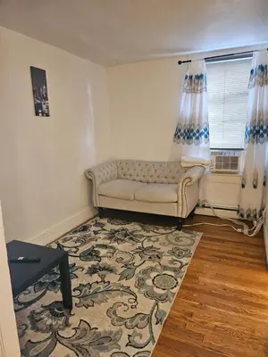 a living room with a couch and a window at UD guest house in East Orange
