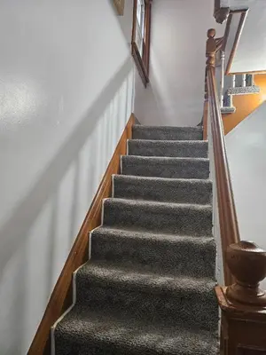 a staircase in a house with grey carpet at UD guest house in East Orange