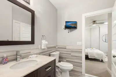 a bathroom with a sink and a toilet and a tv at Lavish 1BR with Pool & Gym Access in Philadelphia