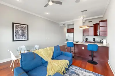 a living room with a blue couch and a kitchen at Lavish 1BR with Pool & Gym Access in Philadelphia
