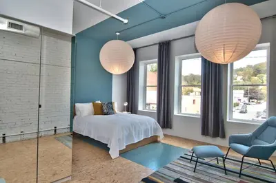 a bedroom with two lamps and a bed and a chair at Wonder Honesdale -Loft A2 in Honesdale