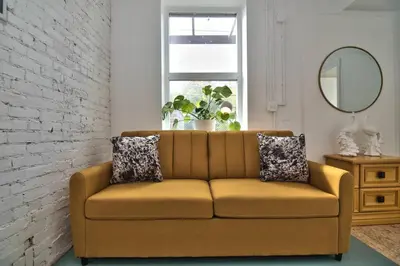 a living room with a couch and a mirror at Wonder Honesdale -Loft A2 in Honesdale