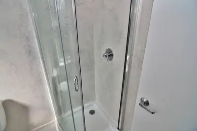 a shower with a glass door and a sink at Wonder Honesdale -Loft A2 in Honesdale