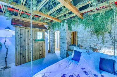 a bedroom with a bed in a room with a stone wall at The Grotto - Unique Interactive Cave Experience in Spring City