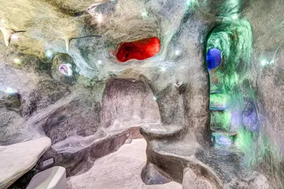 a painting of a cave with a tunnel with red at The Grotto - Unique Interactive Cave Experience in Spring City