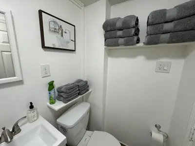 a bathroom with a toilet and a sink and towels at Private Apartment with NYC VIEWS right outside NYC in Jersey City