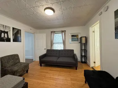a living room with a couch and a chair at Private Apartment with NYC VIEWS right outside NYC in Jersey City