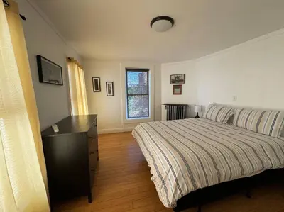 a bedroom with a bed and a dresser and a window at Private Apartment with NYC VIEWS right outside NYC in Jersey City