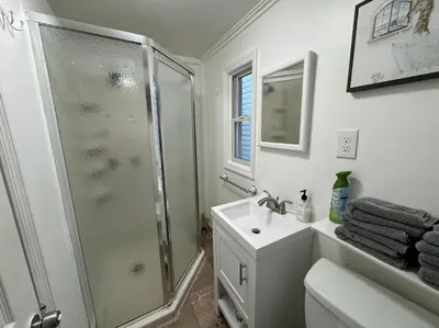a white bathroom with a shower and a sink at Private Apartment with NYC VIEWS right outside NYC in Jersey City