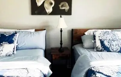 a bedroom with two beds and a table with a lamp at Turquoise Gem in Philadelphia