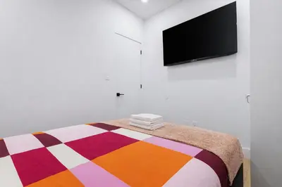 a bedroom with a bed and a flat screen tv at 2 Bedroom Modern Unit in Central Manhattan in New York