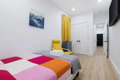 a bedroom with a bed and a yellow chair at 2 Bedroom Modern Unit in Central Manhattan in New York