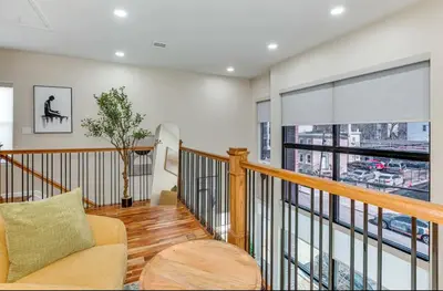 a living room with a couch and a large window at Townhouse - Urban Living with Rooftop Deck! in Newark