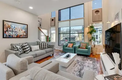 a living room with two couches and a table at Townhouse - Urban Living with Rooftop Deck! in Newark
