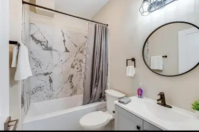 a bathroom with a sink and a toilet and a mirror at Townhouse - Urban Living with Rooftop Deck! in Newark