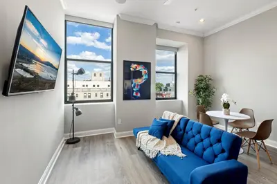 a living room with a blue couch and a table at Magnificent 1BR with Pool & Gym in Philadelphia