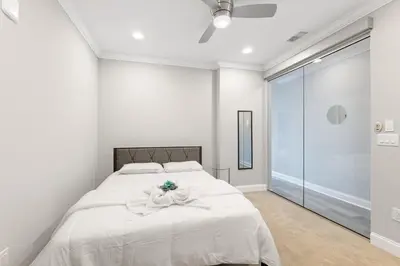a white bedroom with a bed with a flower on it at Magnificent 1BR with Pool & Gym in Philadelphia