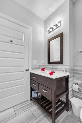 a white bathroom with a sink and a mirror at Chic NoLibs 1BR - Pool & Gym in Philadelphia