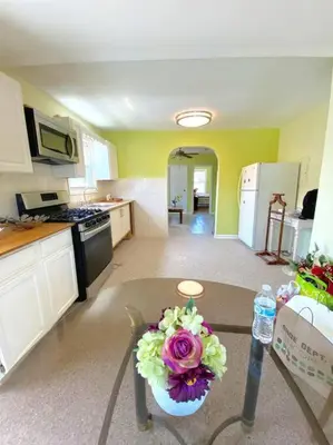 a kitchen with a vase of flowers on a table at 3-bedrooms Journal Square near NYC in Jersey City