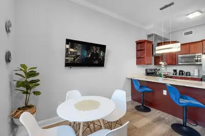 a kitchen with a white table and blue chairs at Modern NoLibs 1BR - Pool & Gym in Philadelphia