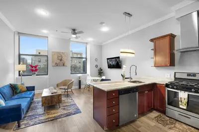 a kitchen and living room with a blue couch at Modern NoLibs 1BR - Pool & Gym in Philadelphia