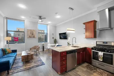a kitchen and living room with a blue couch at Modern NoLibs 1BR - Pool & Gym in Philadelphia