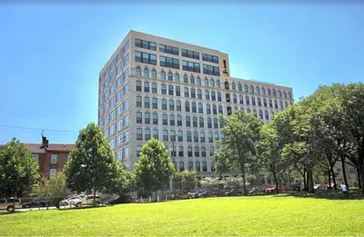 a tall building with a green field in front of it at Modern NoLibs 1BR - Pool & Gym in Philadelphia