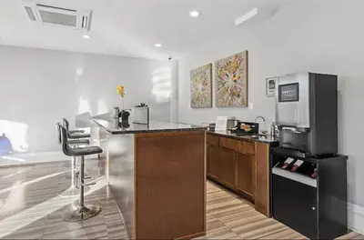a kitchen with a counter and a bar with a refrigerator at Modern NoLibs 1BR - Pool & Gym in Philadelphia