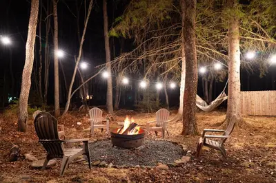 a fire pit at night with chairs and lights at Lakeview! - Close to Skiing - Includes Firepit & Game Room! in Arrowhead Lake