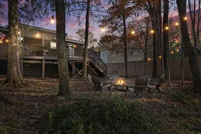 a group of chairs around a table in the woods at night at Lakeview! - Close to Skiing - Includes Firepit & Game Room! in Arrowhead Lake