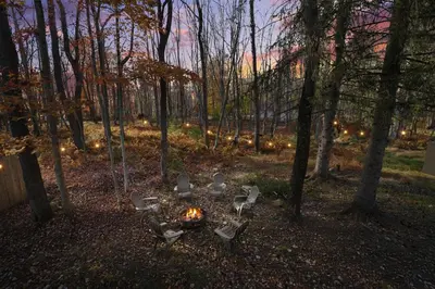 a group of chairs around a fire in the woods at Lakeview! - Close to Skiing - Includes Firepit & Game Room! in Arrowhead Lake