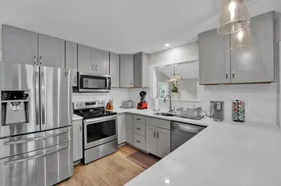 a kitchen with stainless steel appliances and white cabinets at Nature's Paradise with Hot Tub and Fire Pit in Lake Harmony