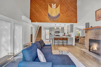 a living room with a blue couch and a fireplace at Nature's Paradise with Hot Tub and Fire Pit in Lake Harmony