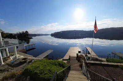 a view of a lake with a house and a flag at Falcon's Nest, Lakefront at Byram Cove, Hopatcong in Andover