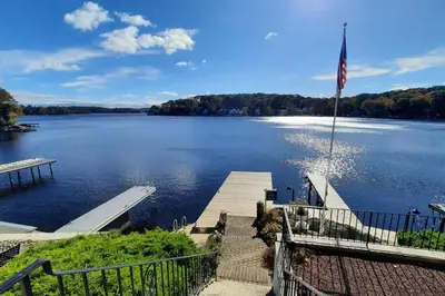a view of a lake with a dock and an american flag at Falcon's Nest, Lakefront at Byram Cove, Hopatcong in Andover