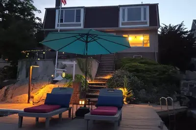 two chairs and an umbrella in front of a house at Falcon's Nest, Lakefront at Byram Cove, Hopatcong in Andover