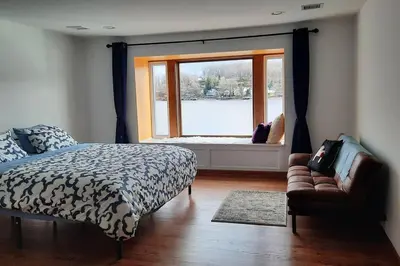 a bedroom with a bed and a window and a couch at Falcon's Nest, Lakefront at Byram Cove, Hopatcong in Andover